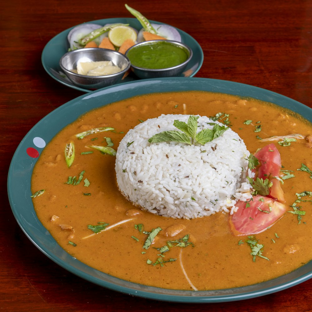 A plate of daal chawal: a mound of steamed basmati rice ringed with daal, finished with fresh mint and coriander